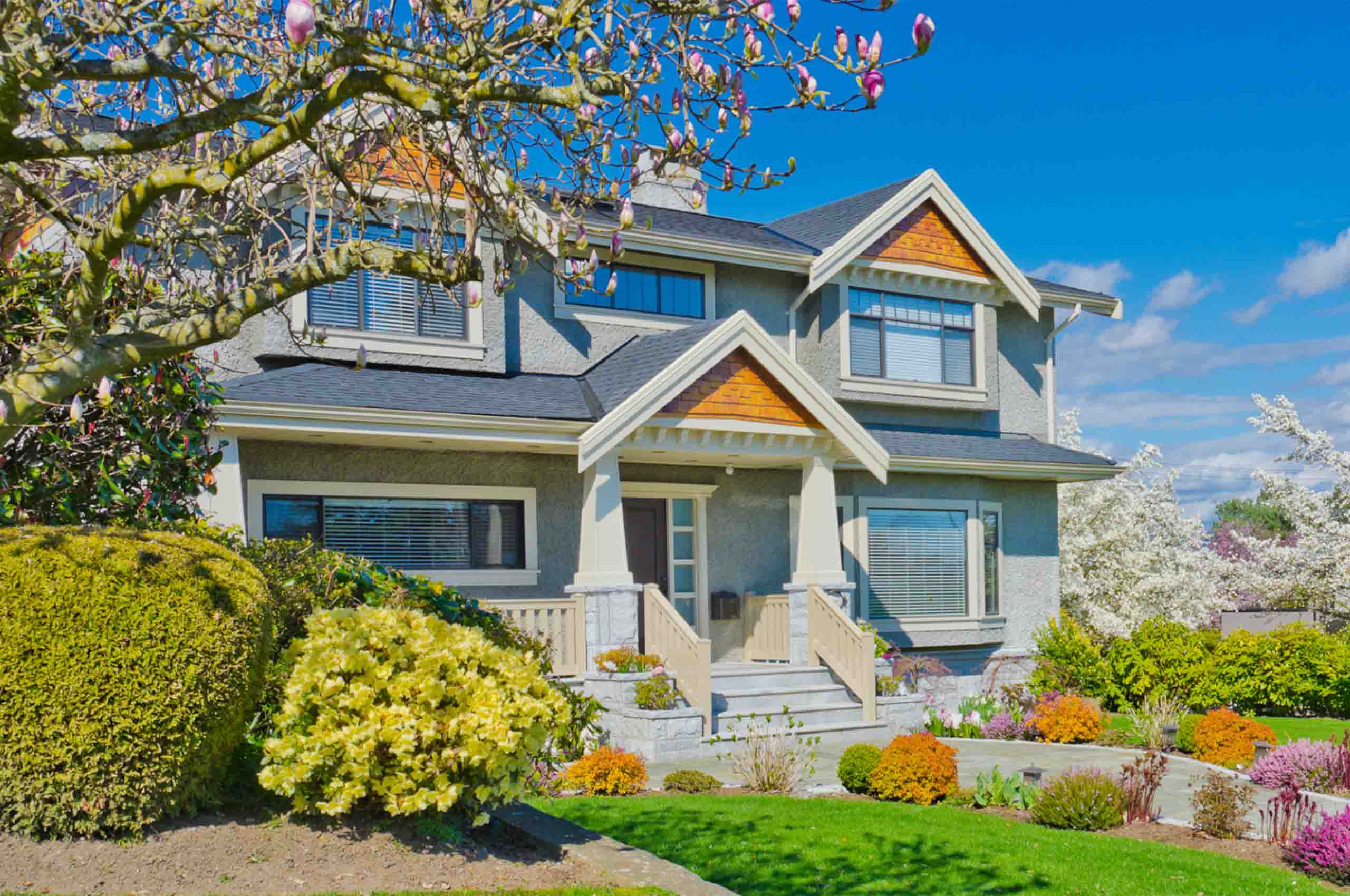 A charming two-story house with a gabled roof and a well-tended garden - https://www.richardgreeninsurance.com/