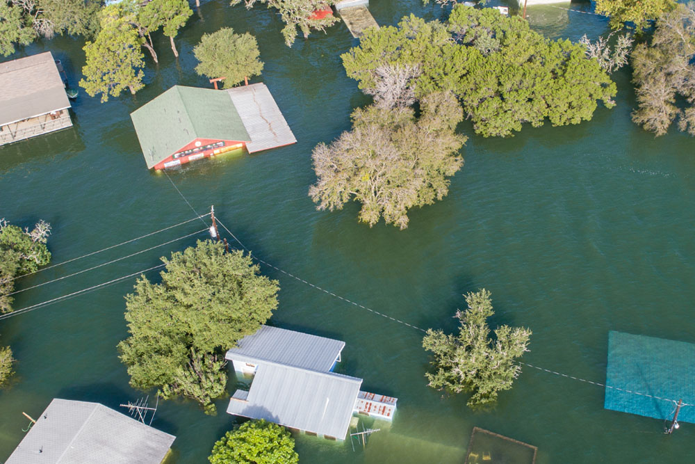 Aerial view of severe flooding with partially submerged houses and trees - https://www.richardgreeninsurance.com/